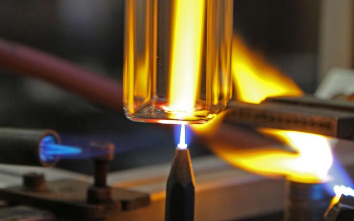 Rectangular glass tubing being heated by blue flame