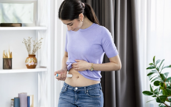 Frau injiziert sich ein Biologika in den Bauch.