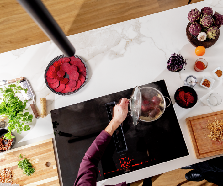 Kitchenette with glass-ceramic hob and various cooking ingredients