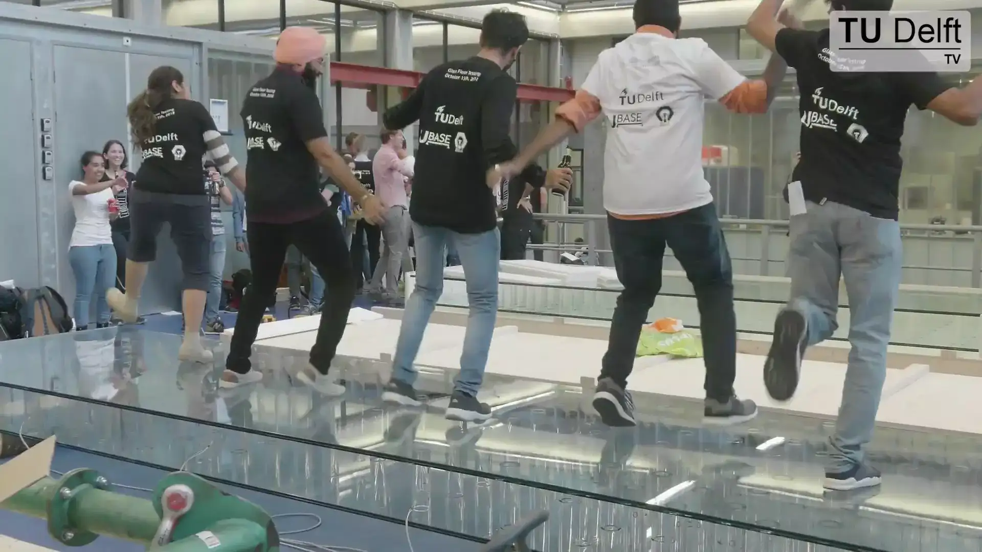Four young people dance on a glass bridge