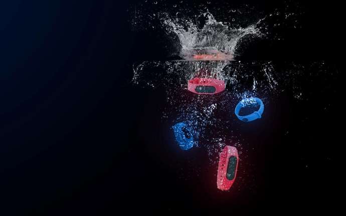 Four blue and red smartwatches dropped in water