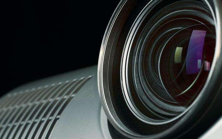 Close up of a projector lens with reflected colors