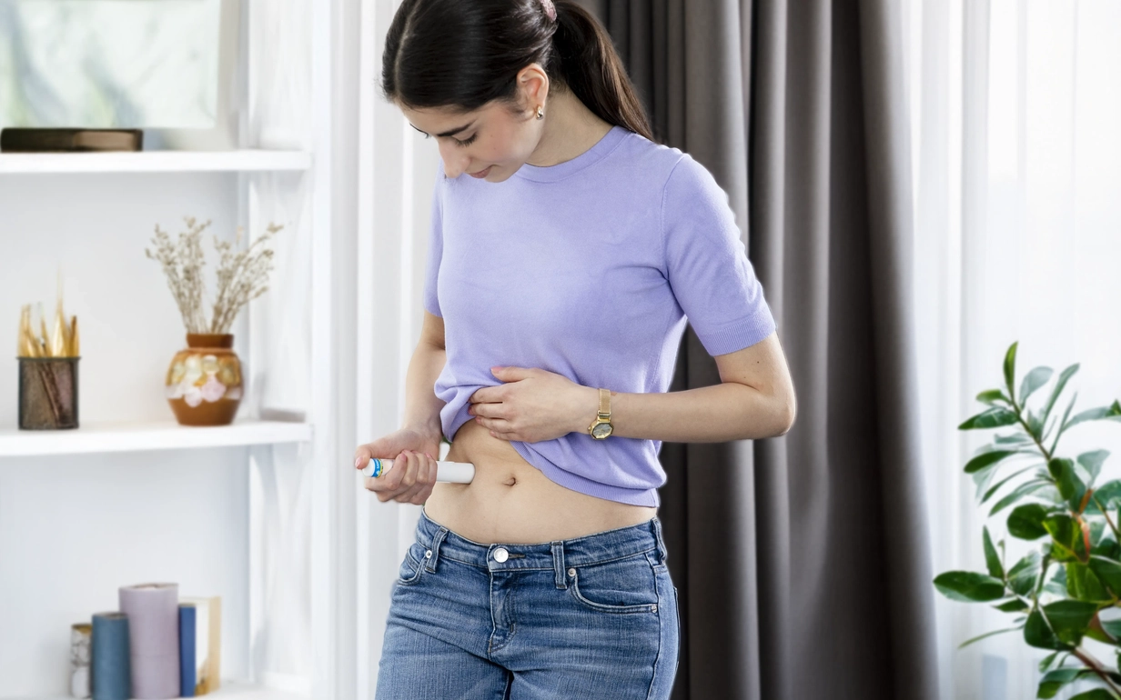 A woman injects a biologic drug into her stomach.