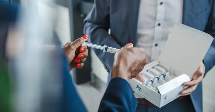 Woman removes a syringe from the blister-free packaging