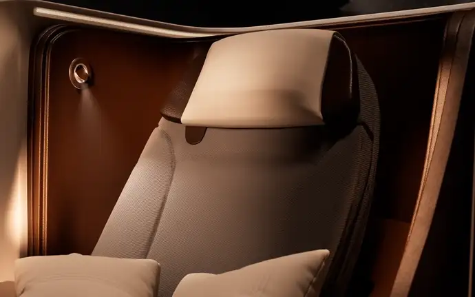 Close-up of an aircraft seat with a reading light installed besides the headrest