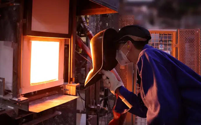 A SCHOTT employee wearing protective gear monitors the production of optical glass using 100% hydrogen for the first time.