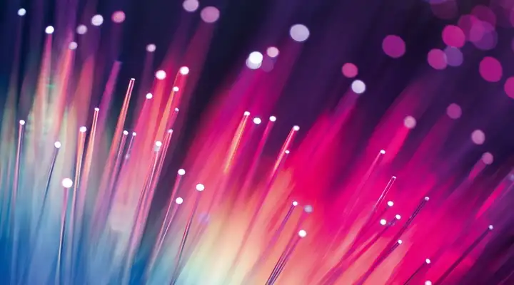 Series of glass optical fibers glowing red and blue