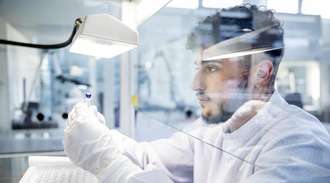 SCHOTT employee inspects a pharmaceutical vial in the lab