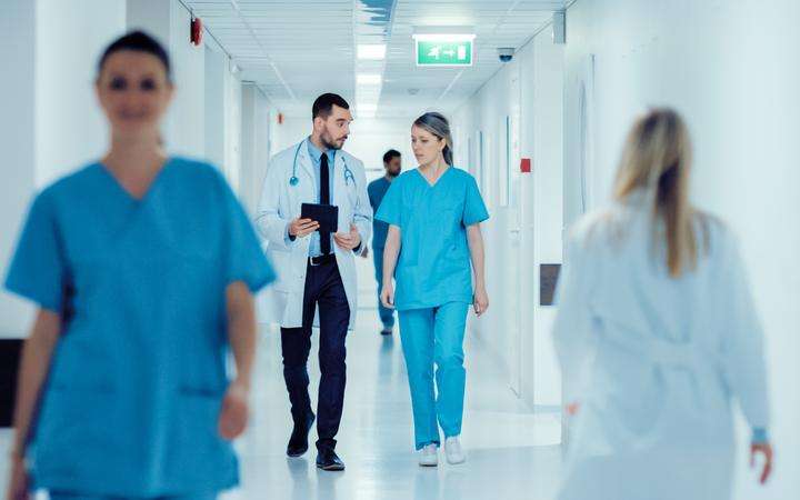 Medical staff walk down a hospital corridor
