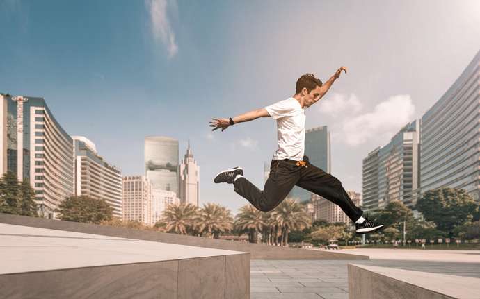 Man jumps across a gap between concrete blocks