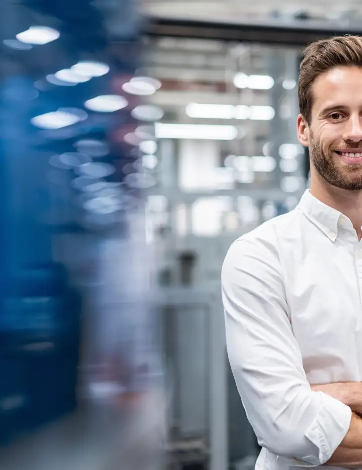 Smiling businessman in a modern factory