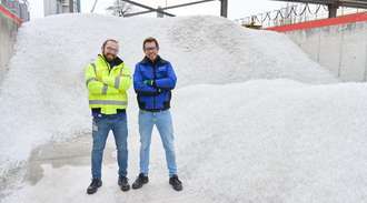 Dr. Tobias Rothenfluh and Marius Amschler stand on a pile of glass in SCHOTT's cullet warehouse in Mainz	