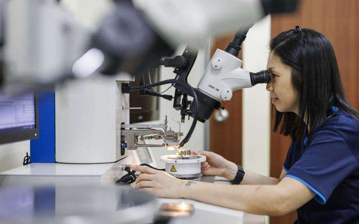 Woman looking through a microscope.