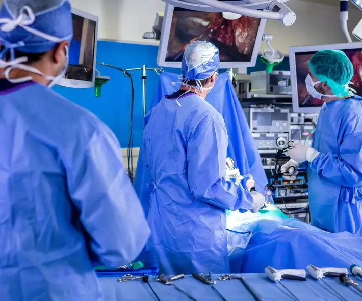 Doctors watch HD monitors while performing minimally invasive robotic surgery