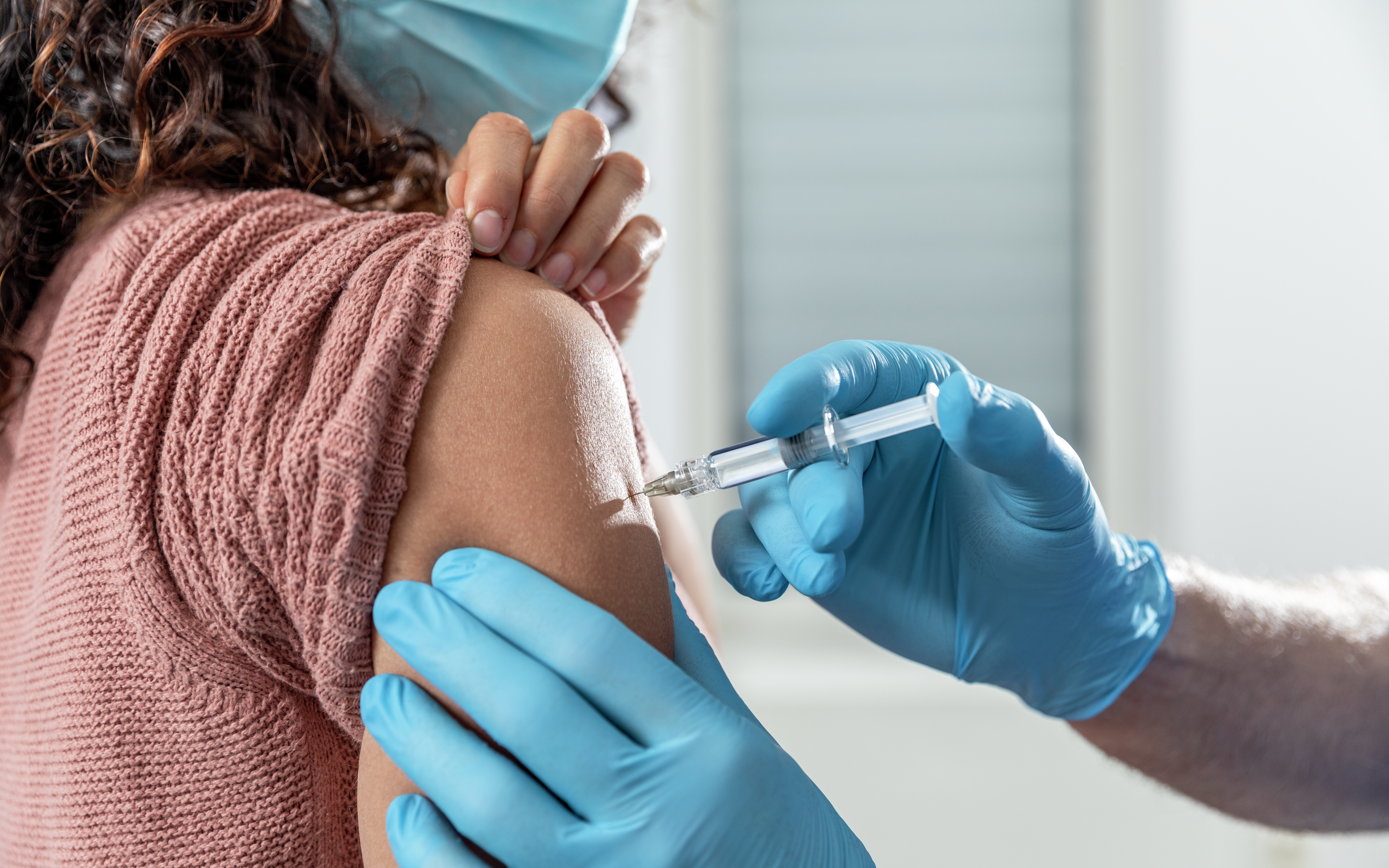 Young woman receiving an injection in her arm