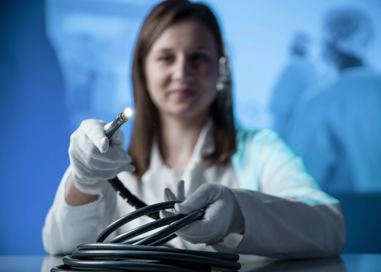 Engineer holds thin optical fibers that are transmitting light