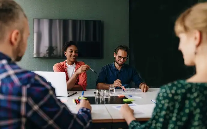 Four people in an informal business meeting