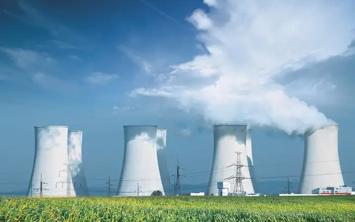 Three white cooling towers emitting white gas