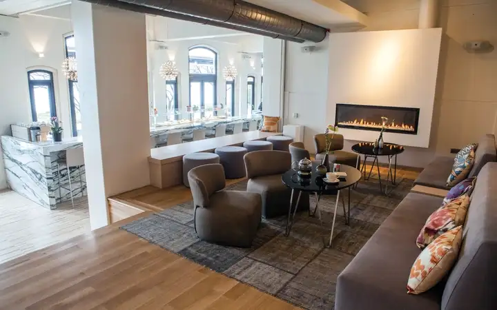 The bar area inside a luxury hotel with a long fireplace