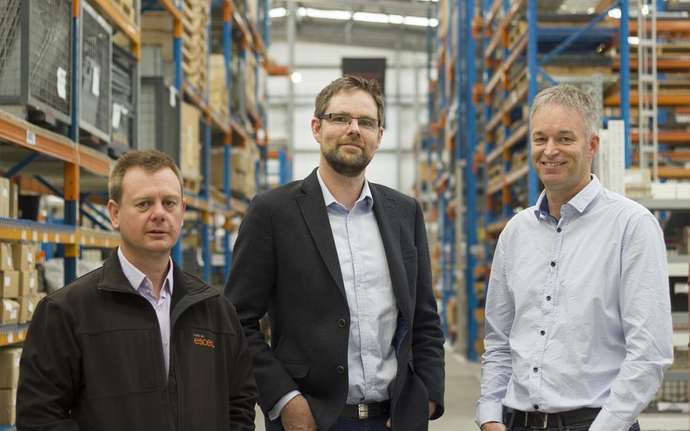 A group of men standing in a warehouse