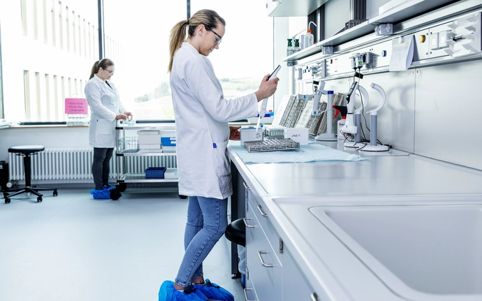 Frau in weißem Kittel im Labor beim Labortest.