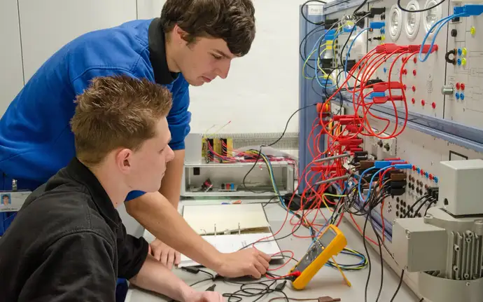 Zwei junge Studenten bedienen elektronische Geräte