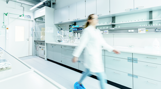 Female technician walks across a laboratory