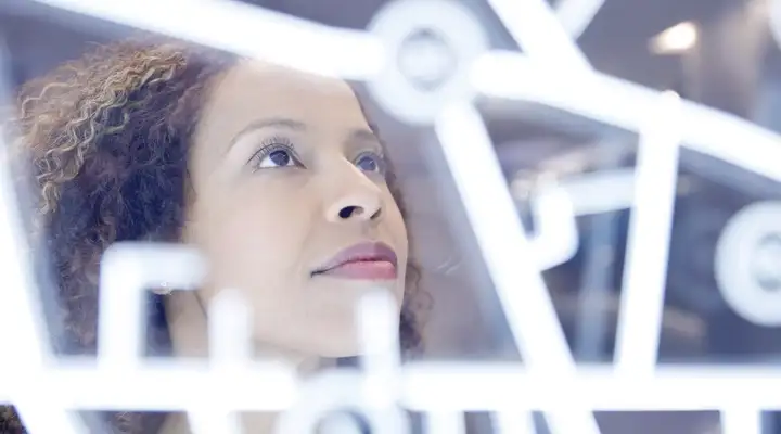 Female looking at illuminated lines on glass panel