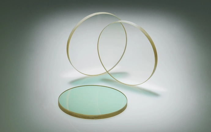 Circular zinc sulfide optical components on a light background.