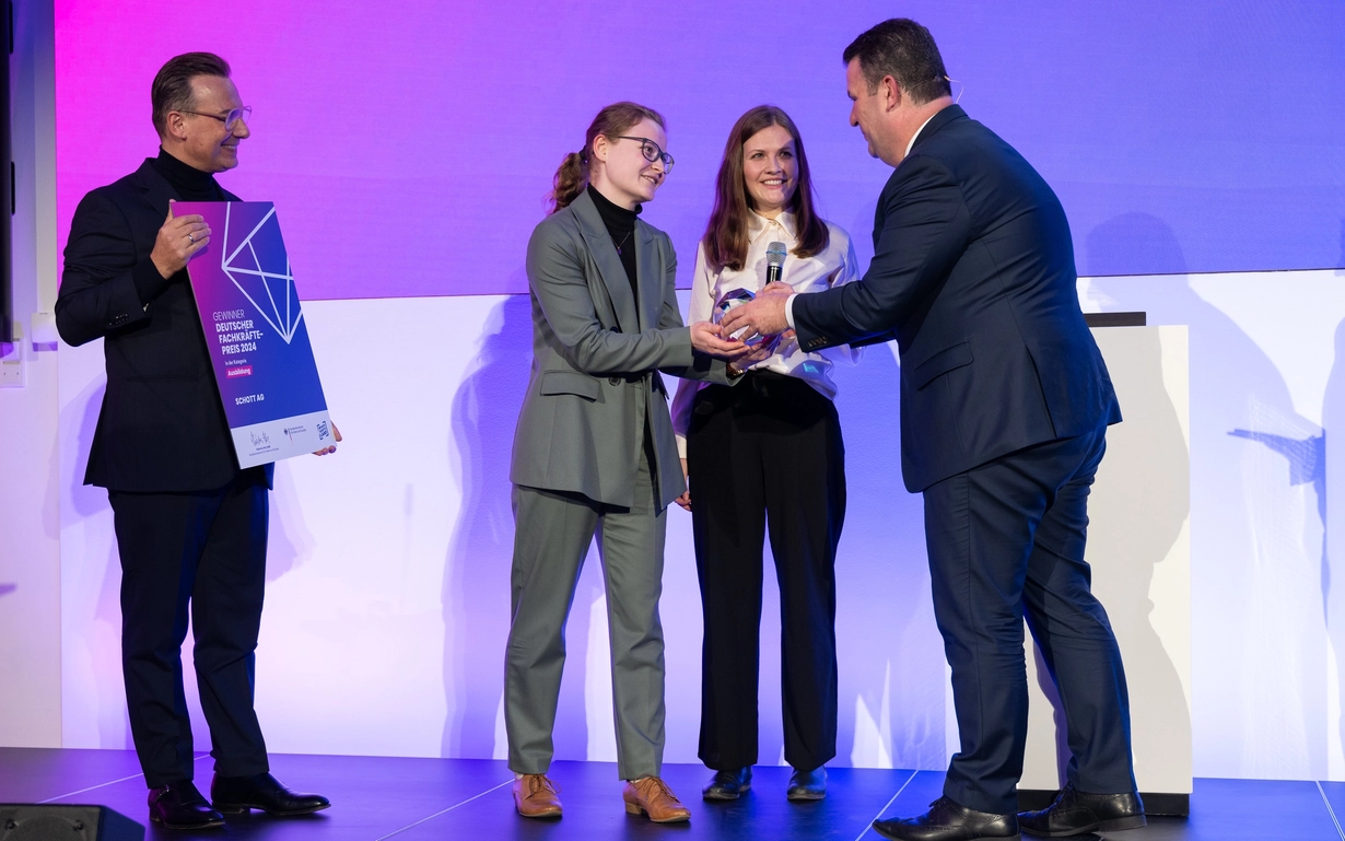 Bundesminister Hubertus Heil (rechts) und Spitzenkoch Tim Raue (links) überreichen den Preis an Vivien Dierichsweiler (2.v.l.), die als Auszubildende bei den Roadshows mitgewirkt hat, und Laura Frost (2.v.r.), HR Specialist der Ausbildung. 