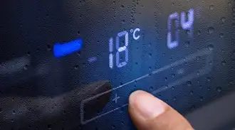 A close-up of a digital glass display, nearly no condensation on the surface, and a finger pressing the "+" button.