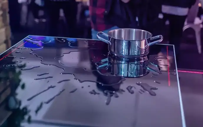 SCHOTT CERAN® glass-ceramic cooktop with splashed water and a pan