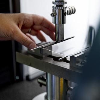 A researcher positions a test sample under a test apparatus.