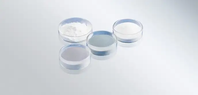 Four glass bowls with different glass powders in various grain sizes and colors