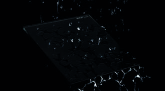 A dark, reflective glass surface with a textured pattern, scattered with water droplets.
