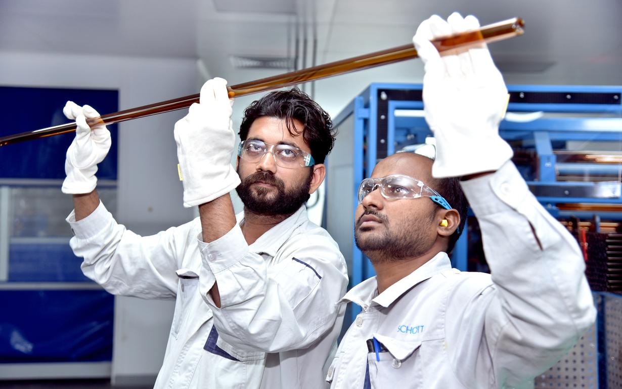 Men checking quality of SCHOTT pharma glass tubing