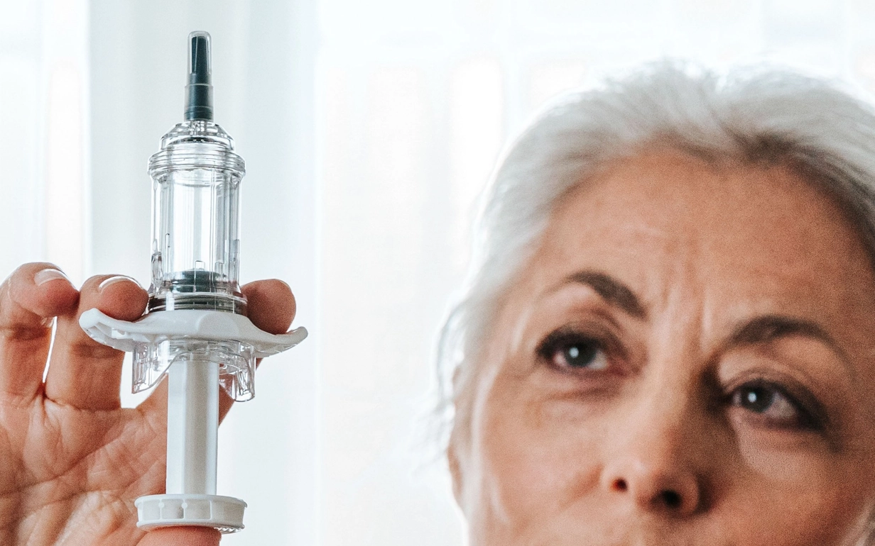 A woman is holding a Safe'n'Sound® system with a syringe in her hand.