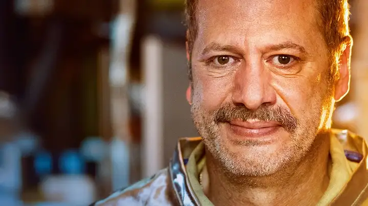 Eine Person trägt in einer industriellen Umgebung eine hitzebeständige Schutzjacke.