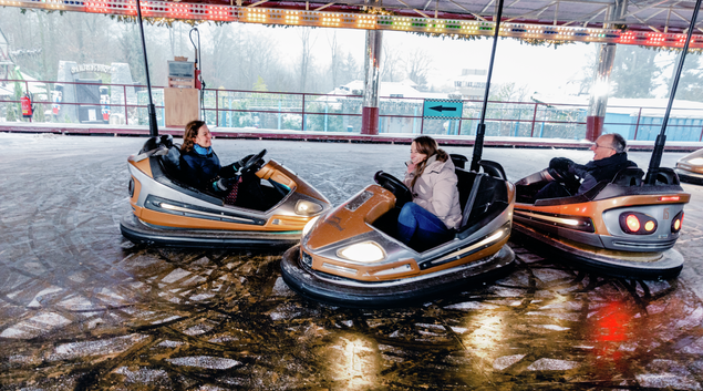 Dr. Andreas Langsdorf, Diana Löber and Stephanie Mangold are laughing while driving bumper cars.