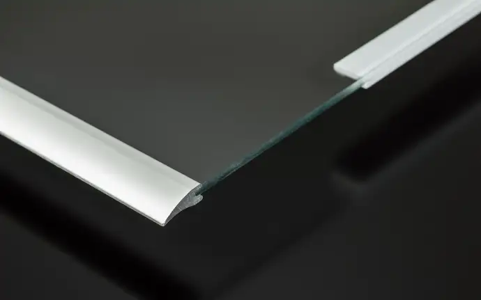 Close-up of a glass refrigerator shelf with sleek aluminum trim on both edges.