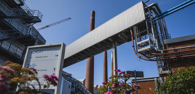 Part of the SCHOTT facility in Mainz with chimneys in the background 