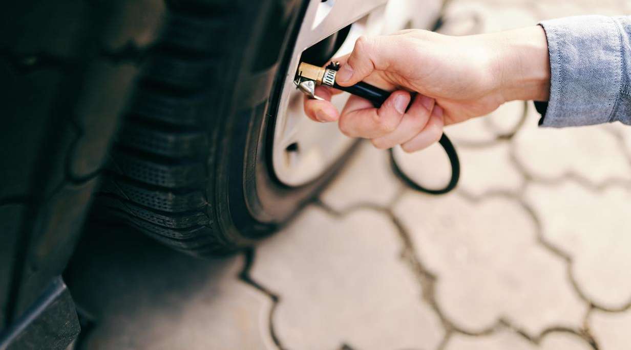 Hand checking the pressure of a car tire	
