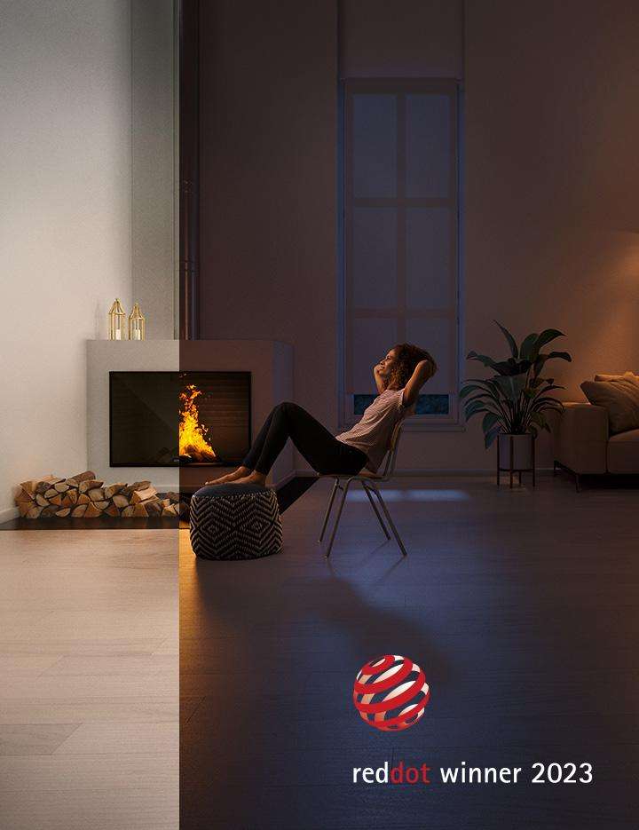 Woman relaxes in front of a wood fireplace with ROBAX® NightFlame fire-viewing panel