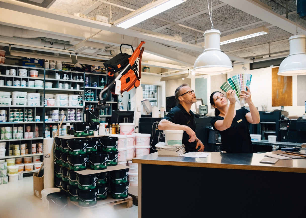 Man and woman in a paint store looking at sample cards