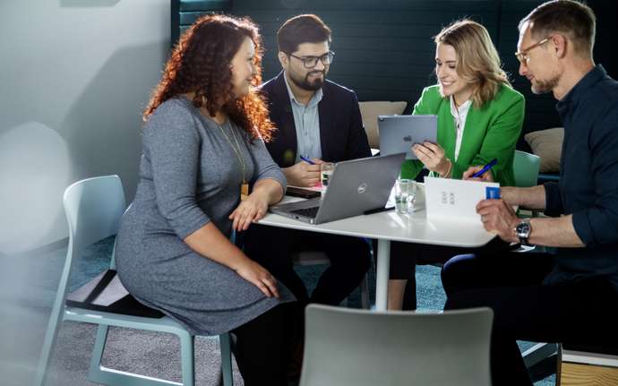 4 people are sitting at the table having a meeting