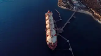 An LNG ship with large tanks is docked.