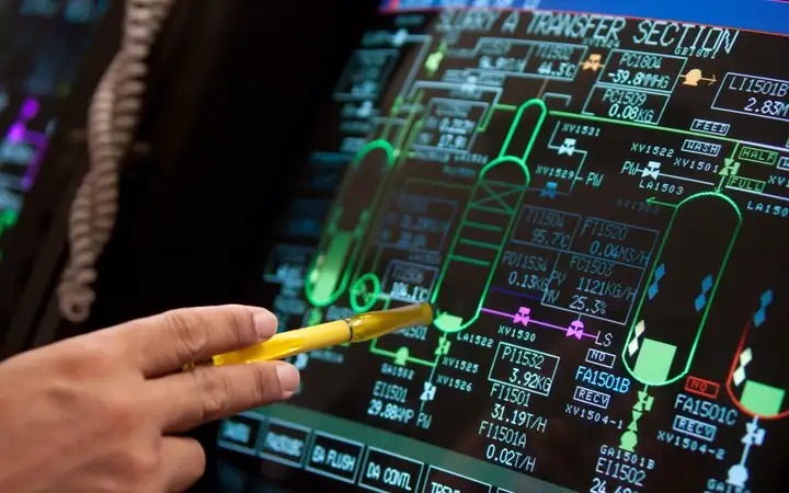 Hand holding a pen pointing at a electronics diagram on a digital screen