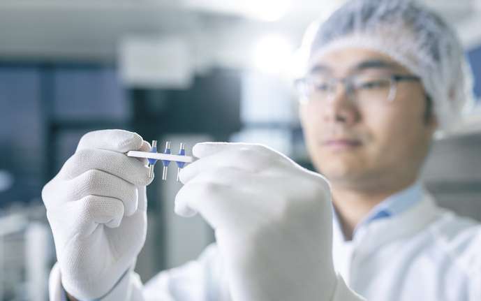 A man inspecting hermetic feedthrough components in a cleanroom