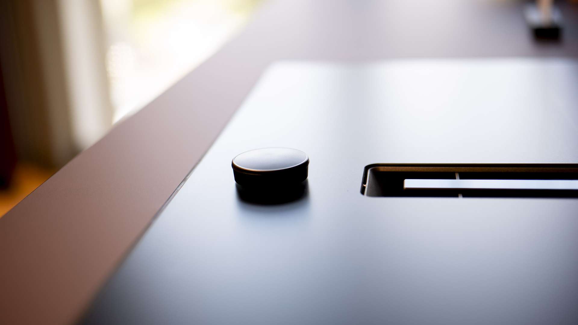 Close-up of a black matte SCHOTT CERAN® cooktop with a round control knob and integrated ventilation slot.