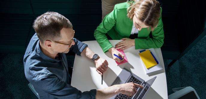 Une femme et un homme travaillant ensemble sur un ordinateur portable